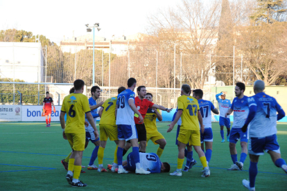 L'àrbitre intenta posar pau després de l'entrada d'un jugador del Tàrrega sobre graells.