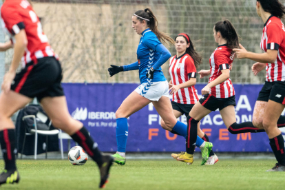 Andrea Gómez porta la pilota, davant la pressió de dos jugadores de l’Athletic Club B.