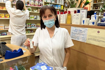 Una profesional muestra uno de los test combinados que se venden en la farmacia Villalonga