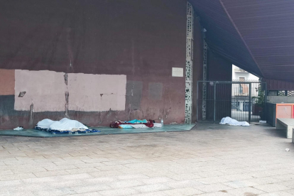 Persones dormint al costat de l'església nova de Sant Martí.