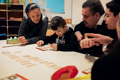 Una família de la comunitat gitana al voltant d’un alumne que fa els deures.