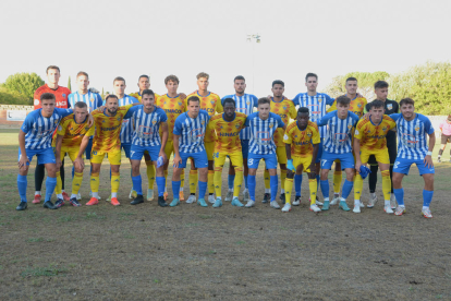 Las plantilla del Lleida y del Artesa de Lleida, en una foto conjunta, ayer antes de empezar el partido.