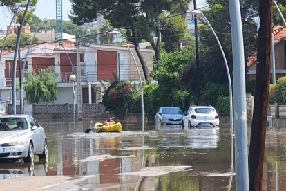 Una piragua navegant dimarts per un carrer inundat de Coma-ruga.