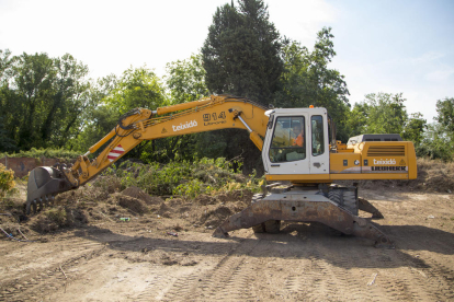 Una excavadora desbrozando ayer el terreno propiedad de Carrefour, por orden de la Paeria.