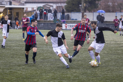 Dos jugadors de l’Horta combinen davant la pressió de dos futbolistes del Tàrrega.