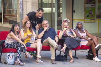 Ferran Orobitg, junto a participantes en su proyecto ‘Opia’ sentados en butacas en medio de la calle.