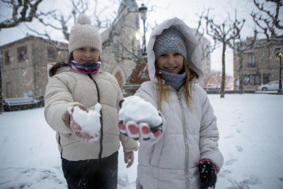 Dos niñas jugando ayer por la tarde con la nieve en Sant Guim de Freixenet.