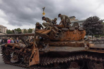 Soldados ucranianos sobre un tanque ruso destruido exhibido en el centro de Kiev.