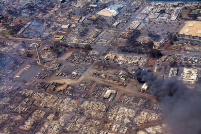 Una fotografía aérea muestra edificios destruidos y árboles quemados a causa de los incendios forestales.