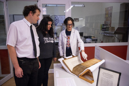 Responsables de l’Arxiu de la Catedral de Lleida, ahir davant d’un dels llibres i documents de la mostra.