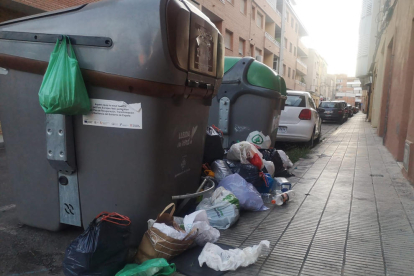 Caixes al costat d’un contenidor de paper i cartró a la plaça Santa Maria Magdalena (Clot).