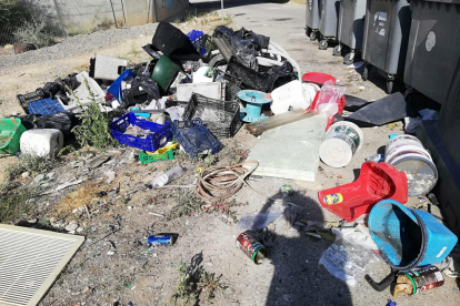 Caixes al costat d’un contenidor de paper i cartró a la plaça Santa Maria Magdalena (Clot).