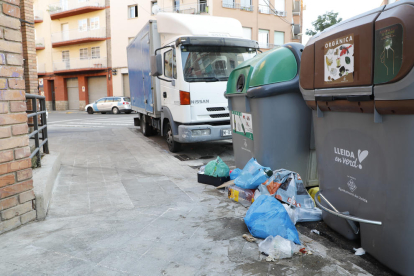 Caixes al costat d’un contenidor de paper i cartró a la plaça Santa Maria Magdalena (Clot).