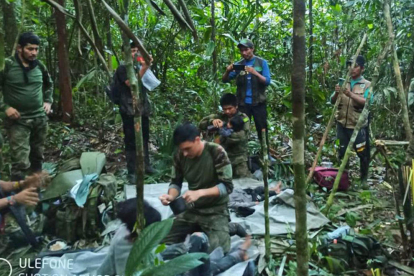 Fotografía cedida hoy por las Fuerzas Militares de Colombia que muestra a soldados e indígenas mientras atienden a los niños rescatados tras 40 días en la selva, en Guaviare (Colombia)