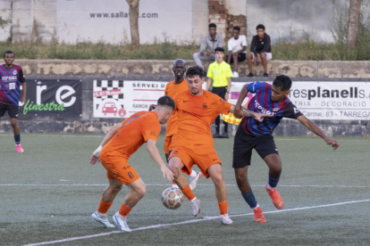 Un jugador del Tàrrega intenta robar-li la pilota a un oponent de l’Atlètic Lleida.