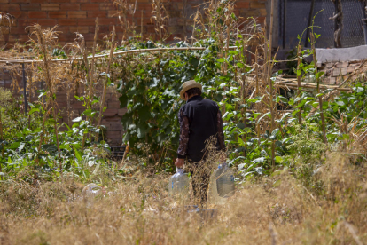 La creadora del huerto, con dos bidones de agua para regar sus hortalizas, ayer por la tarde. 
