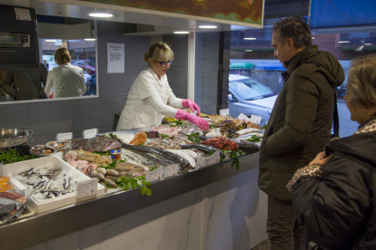 Unos clientes comprando pescado ayer por la mañana en la Pescadería Gil de Lleida.