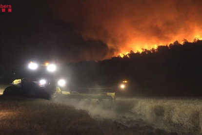 Un tractor llaurant cultius al costat del foc aquesta matinada.