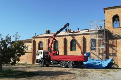 Operarios trabajan en las obras para reformar el tejado de la parroquia de Montserrat de Lleida.