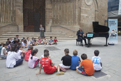 Un grupo de escolares, ayer ante el piano instalado en la plaza de L’Església de Agramunt.