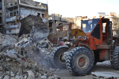 Un home condueix una excavadora per netejar la runa a Alep, Síria.