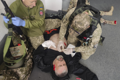 Voluntaris estrangers participen en una classe pràctica de medicina de combat a Kíiv.