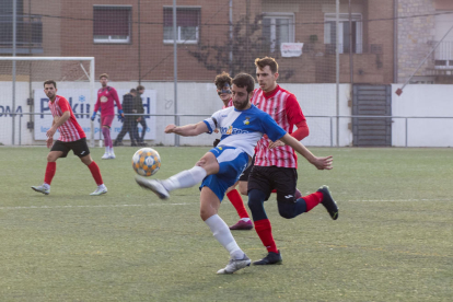 Un jugador del Guissona xuta la pilota per poder controlar-la davant la pressió de diversos rivals.