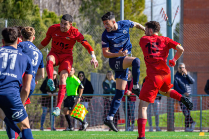 Diversos jugadors dels dos equips disputen una pilota aèria durant el partit d’ahir.