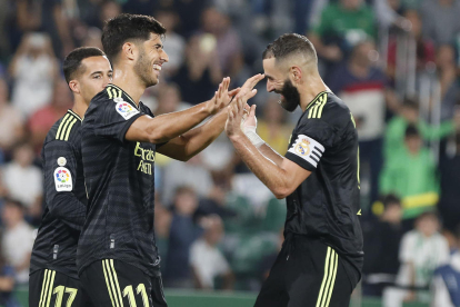 Benzema celebra un gol con Marco Asensio.