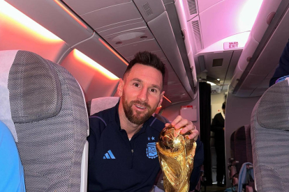 Leo Messi, con la copa del Mundial en el interior del avión de vuelta a Argentina.