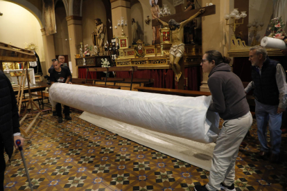 Las restauradoras trabajaron ayer durante todo el día para dejar el manto instalado en la nueva vitrina que lo albergará en la iglesia de La Sang.