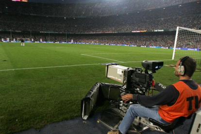 Operari de càmeres treballant durant la retransmissió d’un partit de futbol.