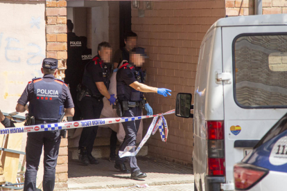 Moment en què els agents van treure la dona, tapada completament amb una manta, de l’habitatge fins a un vehicle policial.