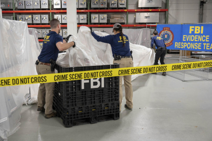 Agentes del FBI manipulan los restos del globo chino derribado.