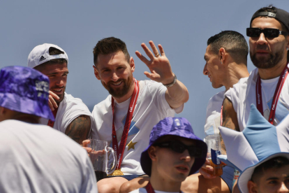 Leo Messi, al costat de De Paul, saluda durant la rua.