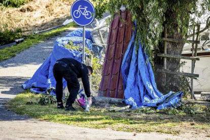 Una persona diposita un ram de flors a l’escena de l’accident.