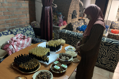 Fouzia Fathi junto a las frutas de argán en sus distintos procesos. Al fondo, muestras de sus productos.