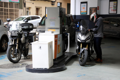El conductor de una moto poniendo combustible en la gasolinera de la calle Legalitat de Barcelona.