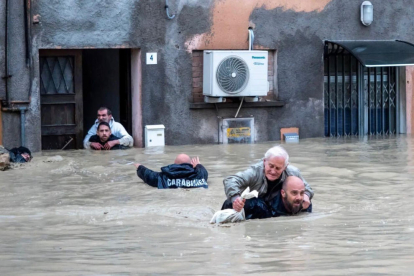 Agents dels Carabinieris italians, evacuant diverses persones de la seua residència inundada a la localitat de Faenza.