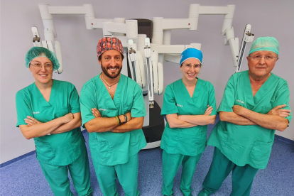 L’equip d’urologia de l’hospital Vithas Lleida posa amb el robot Da Vinci darrere.