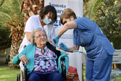 Personal sanitario administra la cuarta dosis de refuerzo de la vacuna contra la covid a Paquita Bonillo, en la residencia Feixa Llarga de L'Hospitalet de Llobregat.