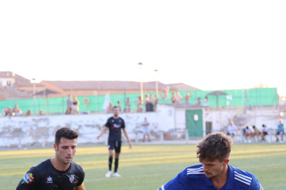 El atacante del Mollerussa Adri Fernández protege la posesión, con Toni Vicente intentando ganarle la posición para robar el balón. 