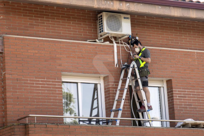 Imatge d'arxiu de tasques de reparació d'un aparell d'aire condicionat a Lleida.