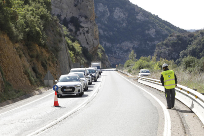 Tres vecinos de Rialp ayer junto a la gran roca que se desprendió el lunes al lado de la gasolinera. 