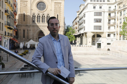 El alcaldable del PP, Xavi Palau, posa con un cartel de su marca, Lleida Implicada, en la plaza Sant Joan. 