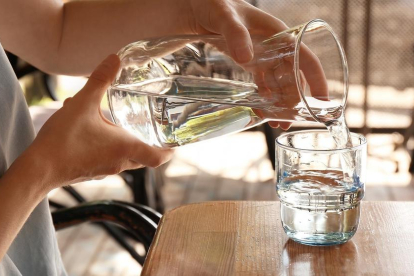 Una persona se sirve agua de una jarra.