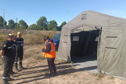 Miembros de la Unidad Militar de Emergencias (UME) y del Consejo de Seguridad Nuclear en Maials (izquierda). A la derecha, Bovera con la central de Ascó al fondo.