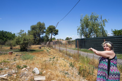 Mari Paz Choren muestra el cable de la luz roto y que se apoya sobre la valla. 