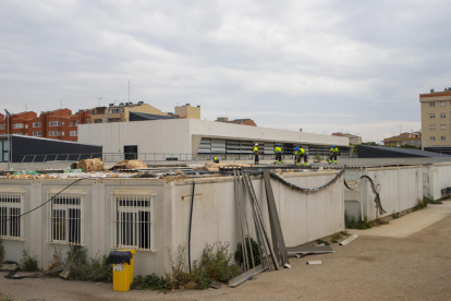 Operaris desmuntant la coberta dels mòduls que han format l’escola Pinyana de Balàfia des del 2009.