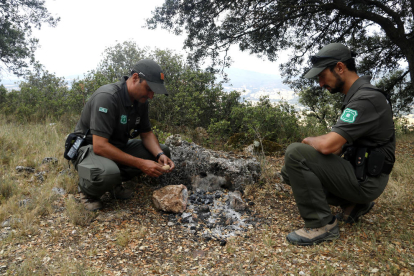 Dos Agents Rurals comprovant les restes d'un foc de camp a la zona de l'Ermita del Puig de Meià